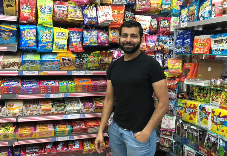 Image: Faizal Ravat, owner of the Hollywood Candy Store in London's Stoke Newington neighborhood, stands in front of his wares.