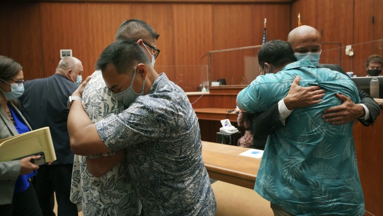 Honolulu Police officers Geoffrey Thom, left, and Christopher Fredeluces embrace as defense attorney Thomas Otake embraces his client Zackary Ah Nee after Judge William Domingo rejected murder and attempted murder charges.