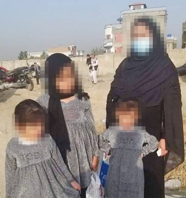 IMAGE: The family of an Afghan interpreter waits at the airport in Kabul to be evacuated