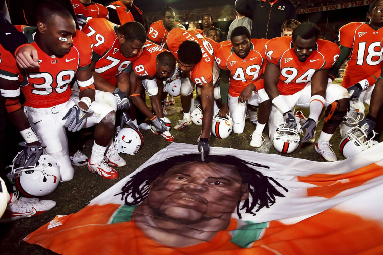 Teammates of Bryan Pata of the University of Miami Hurricanes say a prayer over a mural of Pata at Orange Bowl Stadium on Nov. 23, 2006 in Miami.