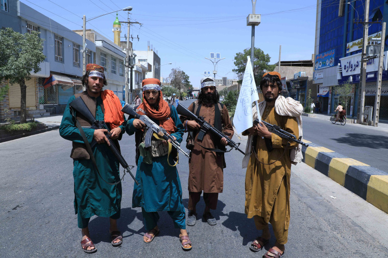 Image: Taliban fighters stand guard along a road near the site of an Ashura procession in Herat