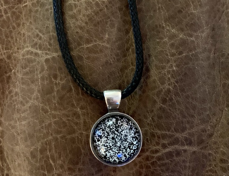 Denise Corliss wears a cherished pendant that has some of Bretagne's ashes encased in glass