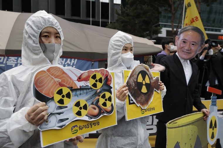 Image: Environmental activists wearing a mask of Japanese Prime Minister Yoshihide Suga and protective suits perform to denounce the Japanese government's decision on Fukushima water, near the Japanese embassy in Seoul, South Korea,