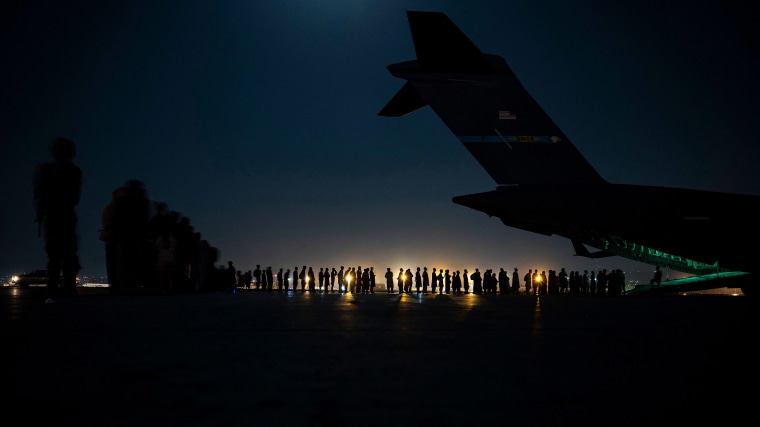 Image: A U.S. Air Force aircrew prepare to load qualified evacuees aboard a C-17 Globemaster III aircraft at Hamid Karzai International Airport.