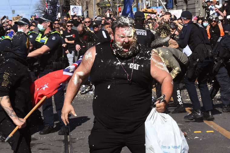 Image: A protester reacts to pepper spray used by police during an anti-lockdown rally in Melbourne on Saturday.