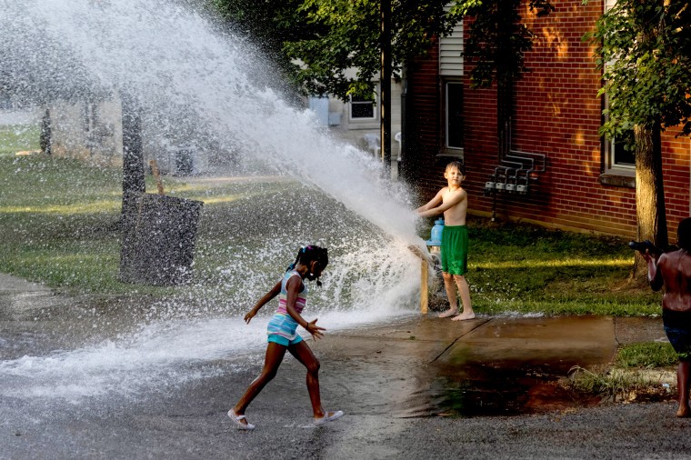 A group of children play with water from an open fire