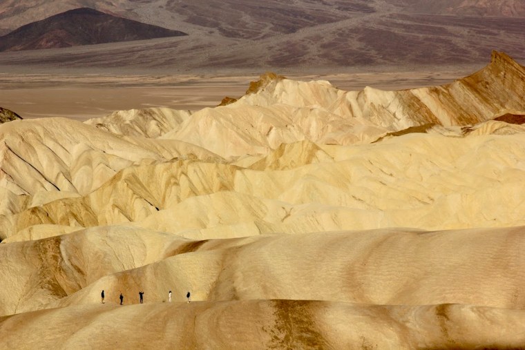 A family hikes from Zabriskie Point to Golden Canyon in Death Valley National Park on March 20, 2021.