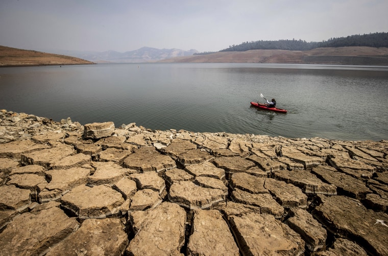 Image: A kayaker fishes in Lake Oroville as water levels remain low due to continuing drought conditions in Oroville, Calif., on Aug. 22, 2021.