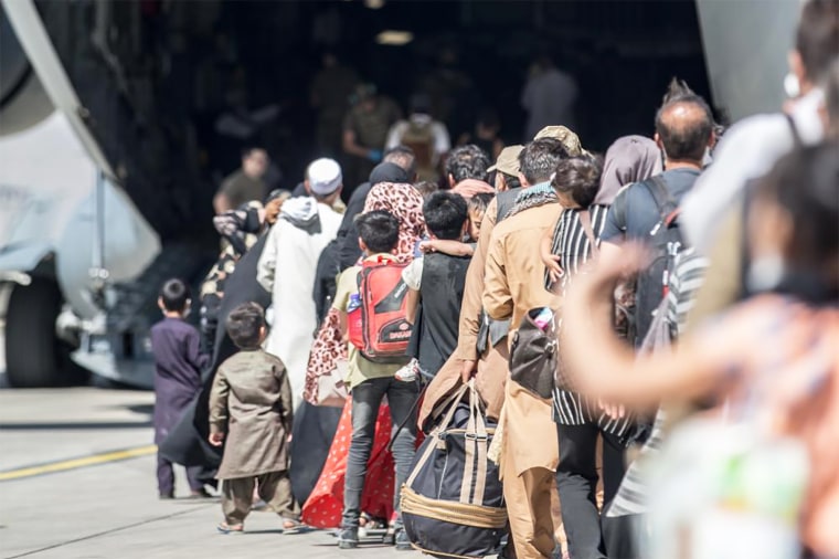 Families board a U.S. Air Force Boeing C-17 Globemaster III during an evacuation at Hamid Karzai International Airport, Kabul, Afghanistan, on Aug. 24, 2021.