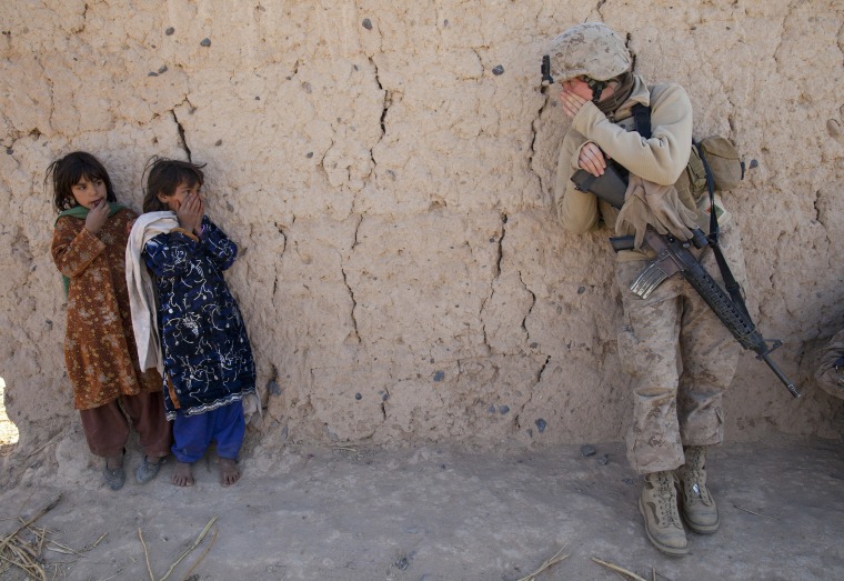 Image: Corporal Catherine Broussard, 22, a US Marine with the FET (Female Engagement Team) tries to communicate with some Afghan girls during a village medical outreach