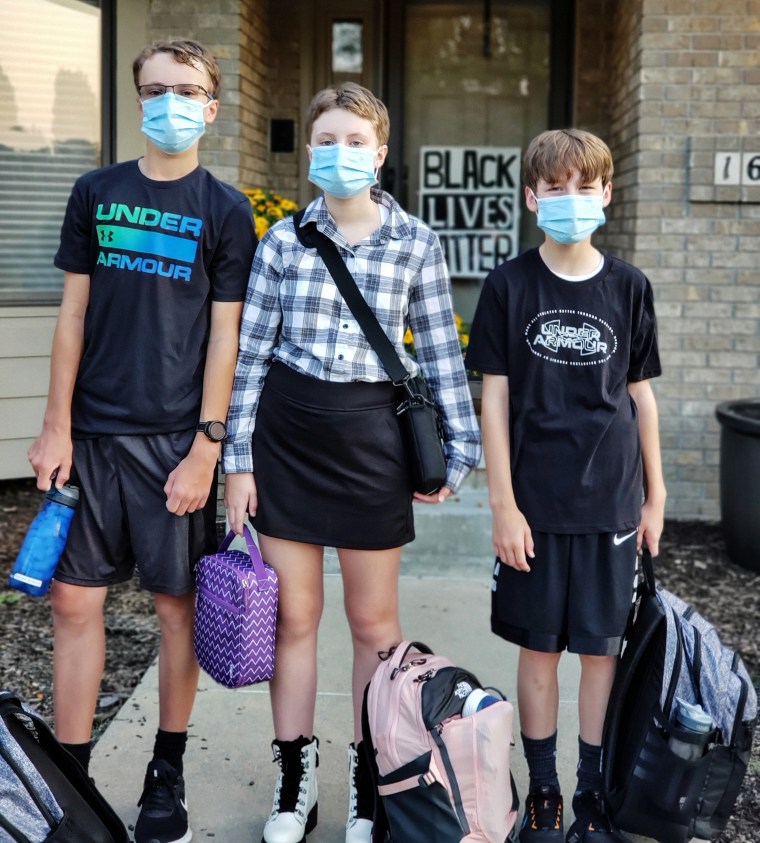 Cindy Maxwell-Ostdiek's children Luke, and Grace and Johnathan on their first day of school. They are among a minority of students who choose to wear masks in class.