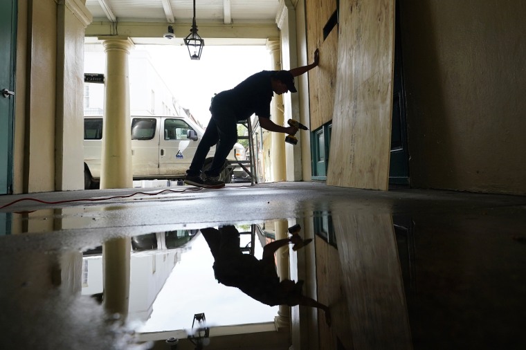 In preparation of Hurricane Ida, a worker attaches protective plywood to windows and doors of a business in the French Quarter in New Orleans on Aug. 28, 2021.