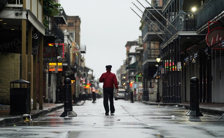 A man walks down a mostly deserted Bourbon Street in the French Quarter as the early effects of Hurricane Ida are felt on Sunday in New Orleans.