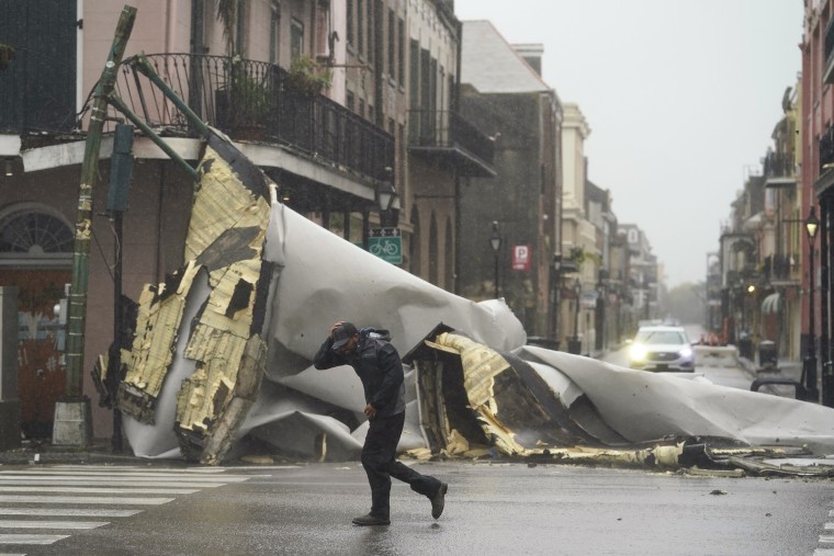 A man passes by a section of roof that was blown off of a building in the French Quarter by Hurricane Ida winds on Aug. 29, 2021, in New Orleans.