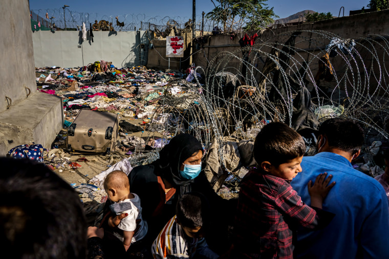 Image: A family near a barred off gate at the airport in Kabul, Afghanistan, on Aug. 25, 2021.