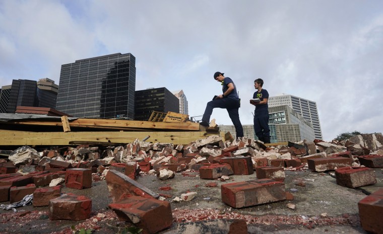 New Orleans firefighters assess damage as they look through debris after a building collapsed from the effects of Hurricane Ida on Aug. 30, 2021.