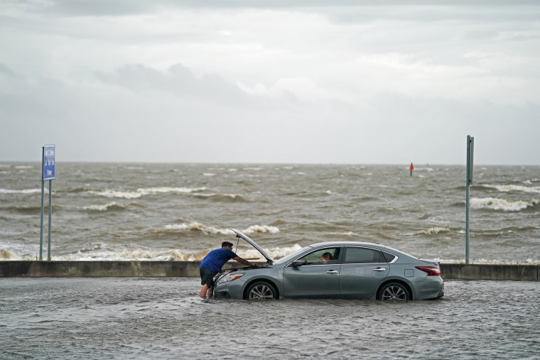 Image: A man helps a stranded motorist in floodwaters in Biloxi, Miss., on Monday.