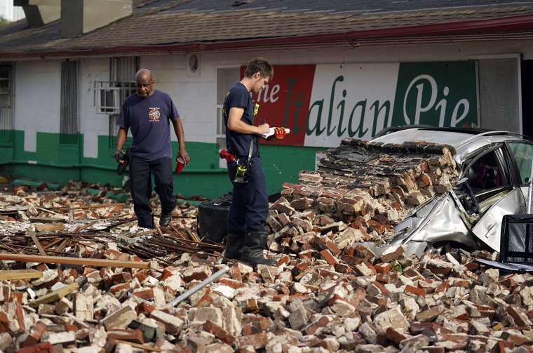 Image: Firefighters assess damage on Monday as they look through debris from a collapsed building in New Orleans.