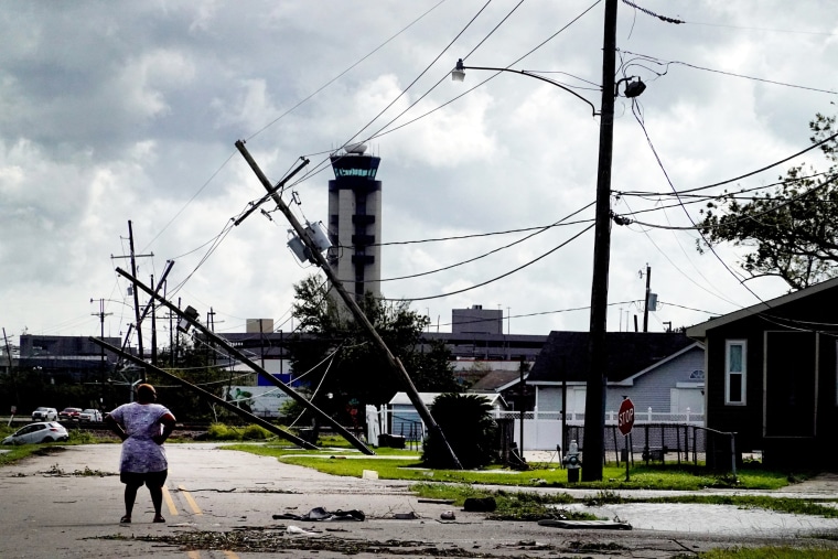 A woman looks over damage caused by Hurricane Ida on Aug. 30, 2021, in Kenner, La.