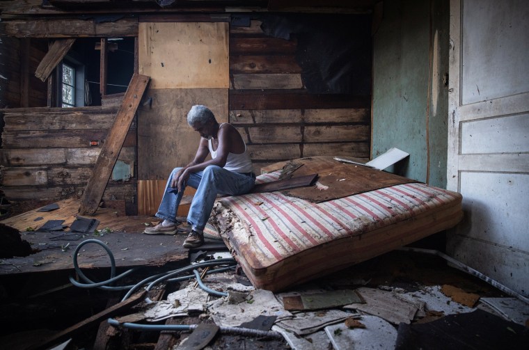 Theophilus Charles, 70, sits inside his house which was heavily damaged by Hurricane Ida in Houma, La., on Aug. 30, 2021.