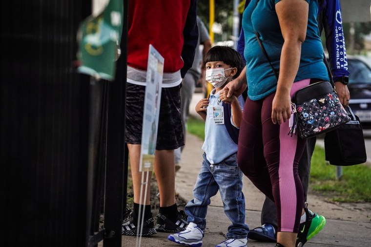 A student and his parents walk into an elementary school on the first day of school in Houston, Texas, on Aug. 23, 2021.