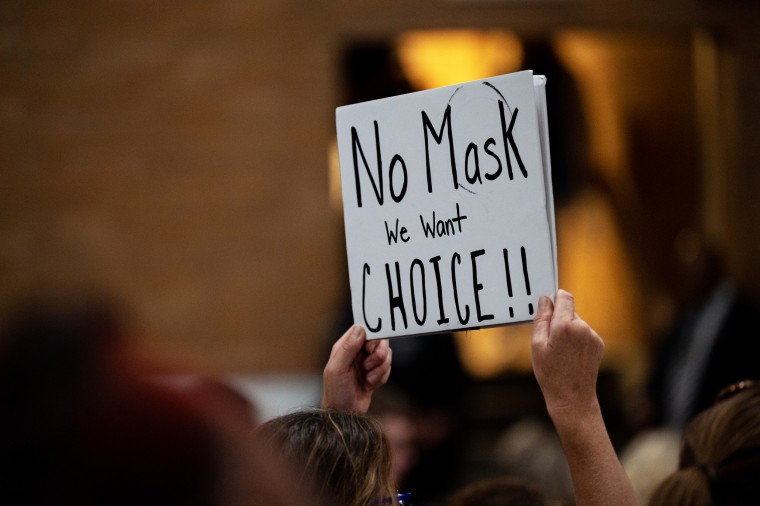 A demonstrator holds a sign protesting against mask mandates during a school board meeting for the Jefferson County Public Schools district in Louisville, Ky., on July 27, 2021.