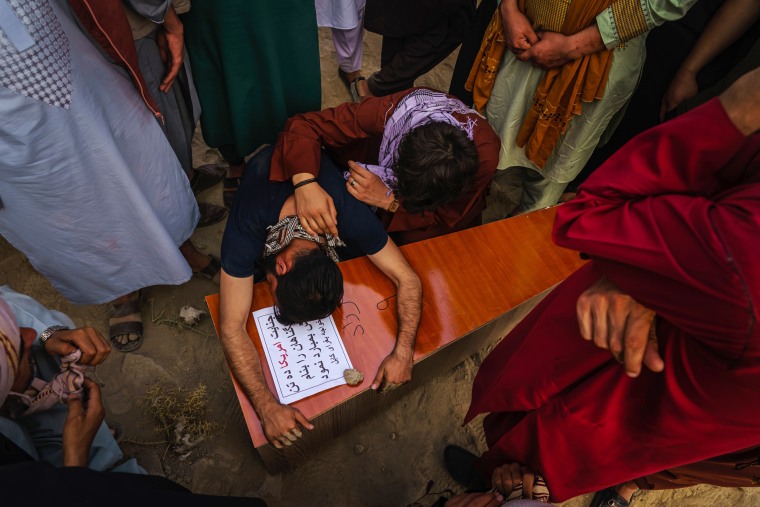 Image: A relative throws himself and weeps over Farzad's casket.