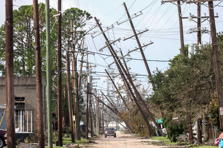 Image: Utility poles lean over a street following Hurricane Ida on Tuesday in Houma, La.