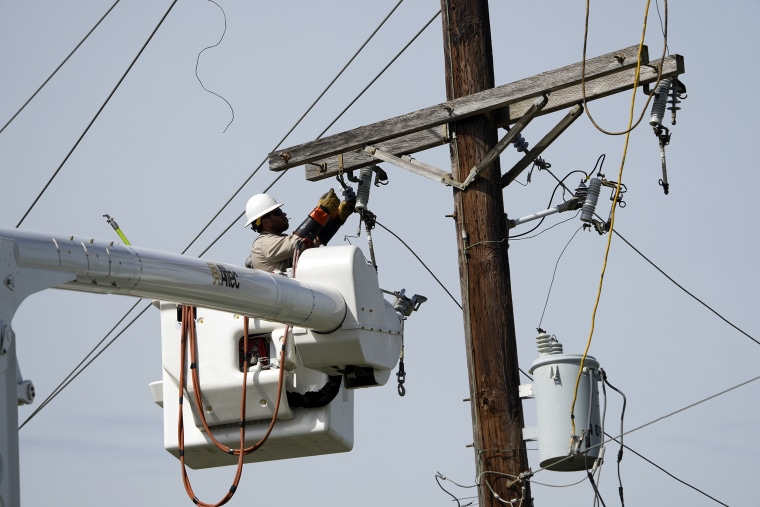 Image: A power company employee works on a line on Aug. 31, 2021, in Houma, La., in the aftermath of Hurricane Ida.