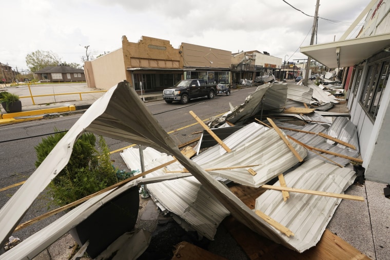 Image: Traffic passes by piles of debris on the sidewalk of Main Street in downtown as residents try to recover from the effects of Hurricane Ida on Aug. 31, 2021, in Houma, La.