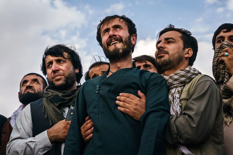 Image: Ramal Ahmadi is supported by family members during a mass funeral in Kabul on Monday.