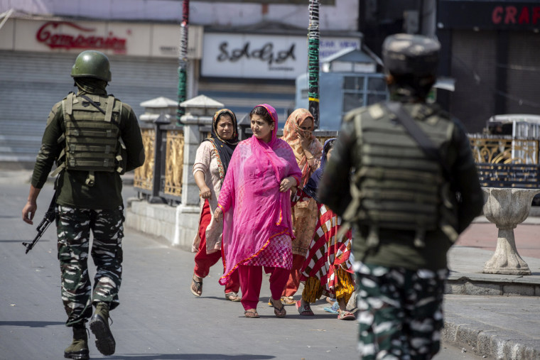 Image: Indian paramilitary soldiers patrol the streets as civilians walk in Srinagar, in Indian controlled Kashmir on Thursday.