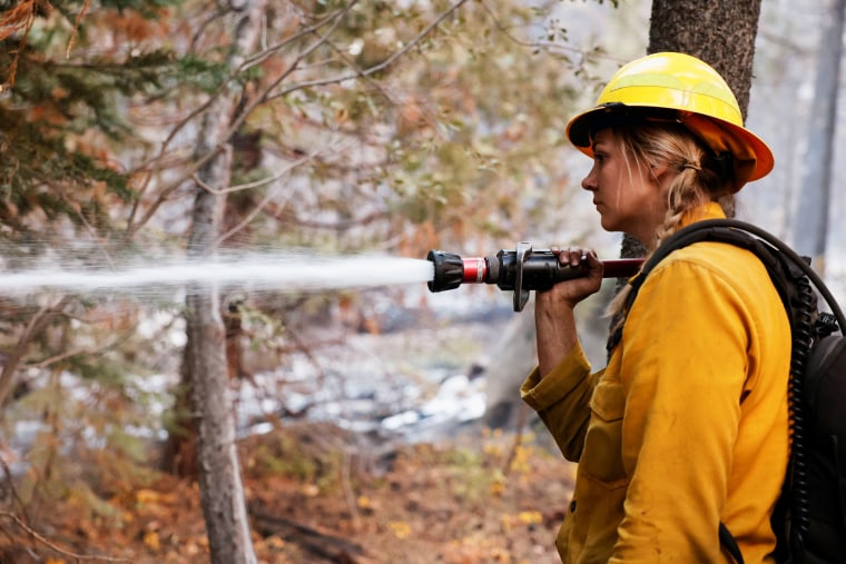 Stephanie Lockhart of North Tahoe Fire knocks down hot spots in South Lake Tahoe, Calif., on Sept. 1, 2021.