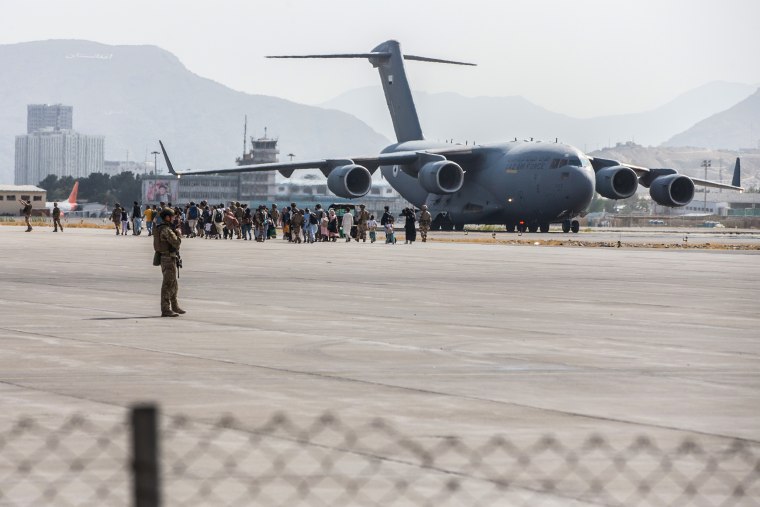 Evacuees load on to a U.S. Air Force Boeing C-17 Globemaster III during an evacuation at Hamid Karzai International Airport, Kabul, Afghanistan, Aug. 21., 2021.