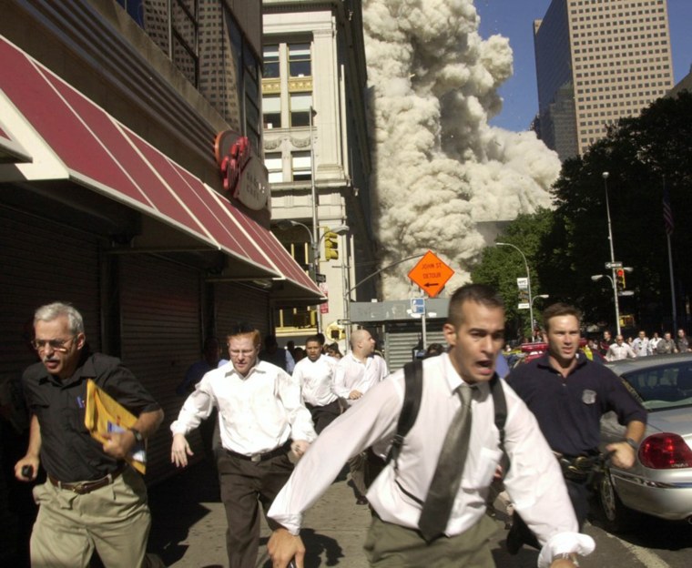 Pedestrians run for cover after the collapse of the south tower.