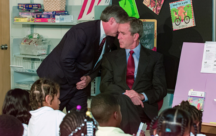 White House chief of staff Andrew Card whispers into the ear of President George W. Bush