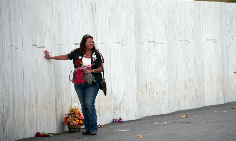 A family member touches the name of Mark Bingham during the 13th anniversary ceremonies commemorating the Sept. 11 attacks at the Wall of Names at the Flight 93 National Monument in Shanksville, Pa., on Sept. 11, 2014.