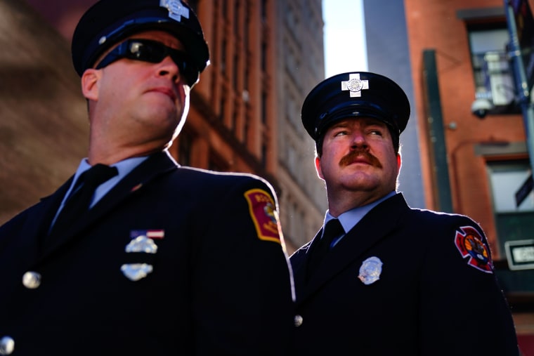 Firefighters from Massachusetts gather with others outside the National September 11 Memorial and Museum.