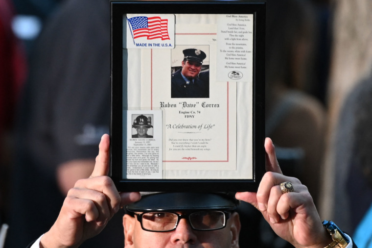 A fireman holds up the image of a 9/11 victim