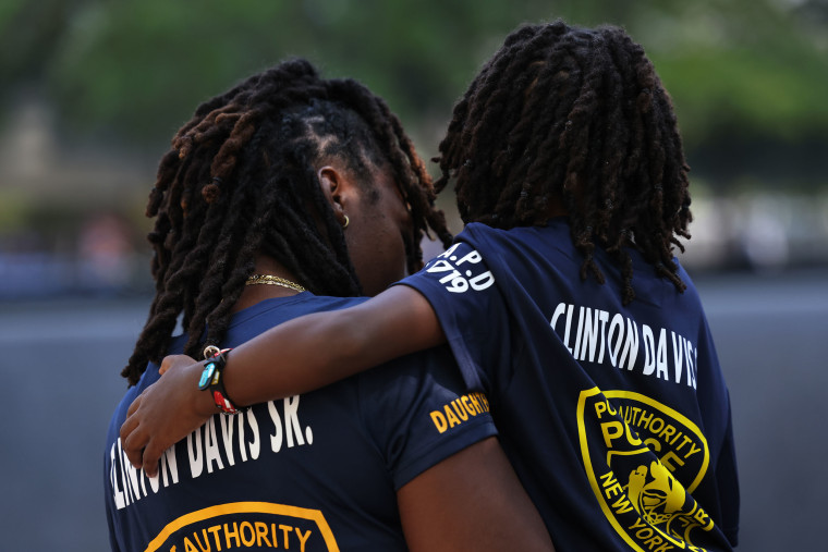 Priscella Davis, daughter of fallen Port Authority Police Officer Clinton Davis Sr., holds her son Jaxson, 4, as they view his name.