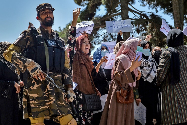 Image: A Taliban fighter stands guard as Afghan women shout slogans during a protest rally near Pakistan's embassy in Kabul on Tuesday.