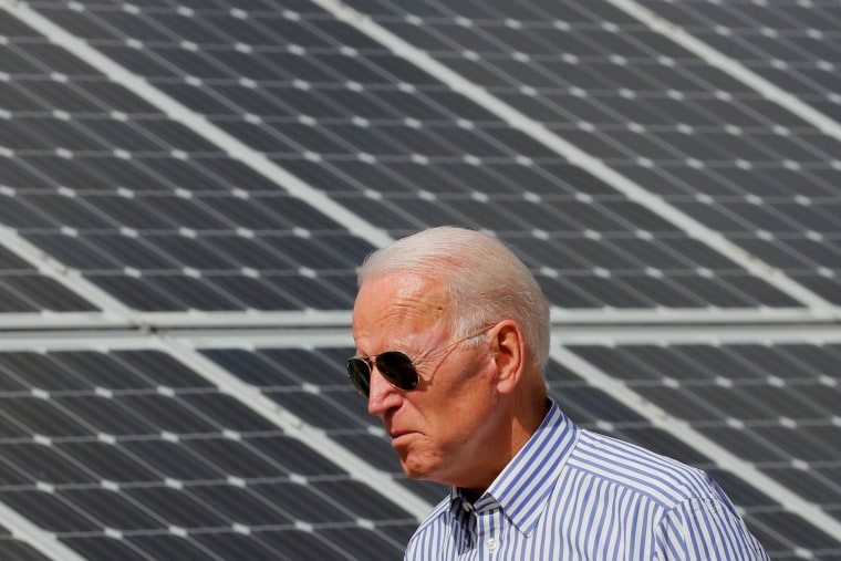 Then-candidate Joe Biden walks past solar panels while touring the Plymouth Area Renewable Energy Initiative in Plymouth, N.H., on June 4, 2019.