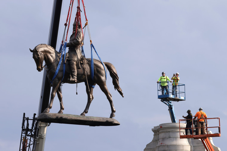 The statue of Robert E. Lee is lowered from its pedestal on Sep. 8, 2021 in Richmond, Va.