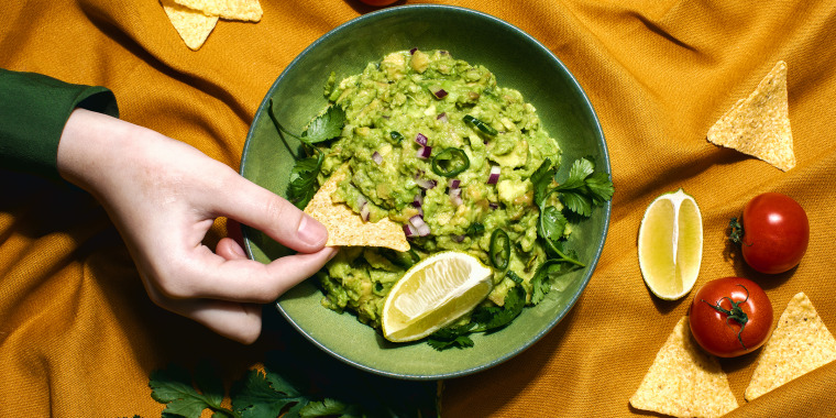 Guacamole served with nachos in an olive green bowl