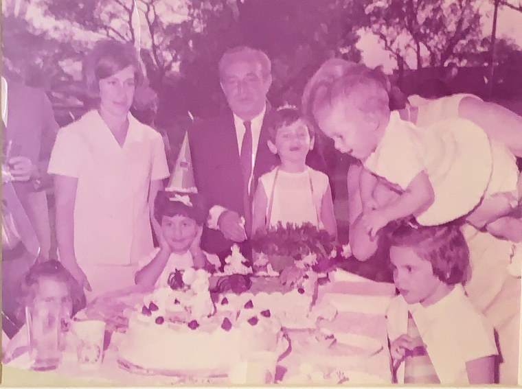 Yael Federbush, shown here at around 10 months old, is held by her grandmother and surrounded by family while celebrating a friend's birthday party. 