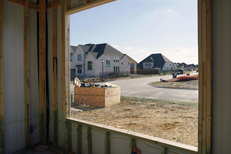 New homes are seen through the window of one under construction in Frisco, Texas.