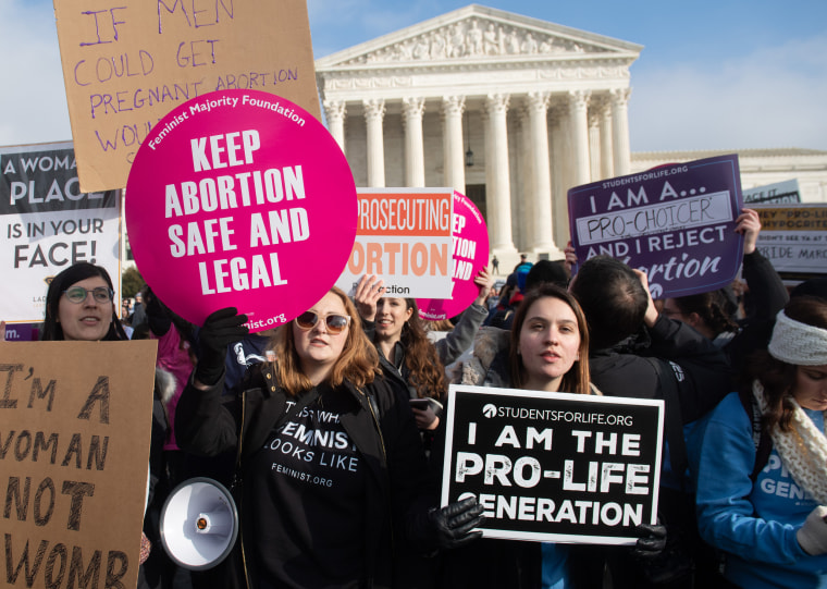 Abortion rights activists hold signs alongside anti-abortion activists outside the Supreme Court in 2019.