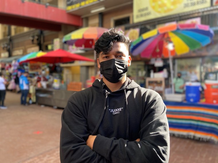 Jesús Morales, aka @juixxe on TikTok, poses with street food carts.