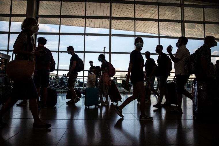 Travelers walk through the departures hall in El Prat airport in Barcelona on Aug. 2, 2021.
