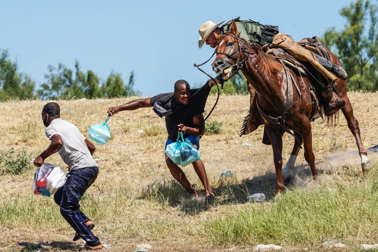 A border patrol agent on horseback tries to stop a Haitian migrant from entering an encampment on the banks of the Rio Grande near the Acuna Del Rio International Bridge in Del Rio, Texas, on Sept. 19, 2021.